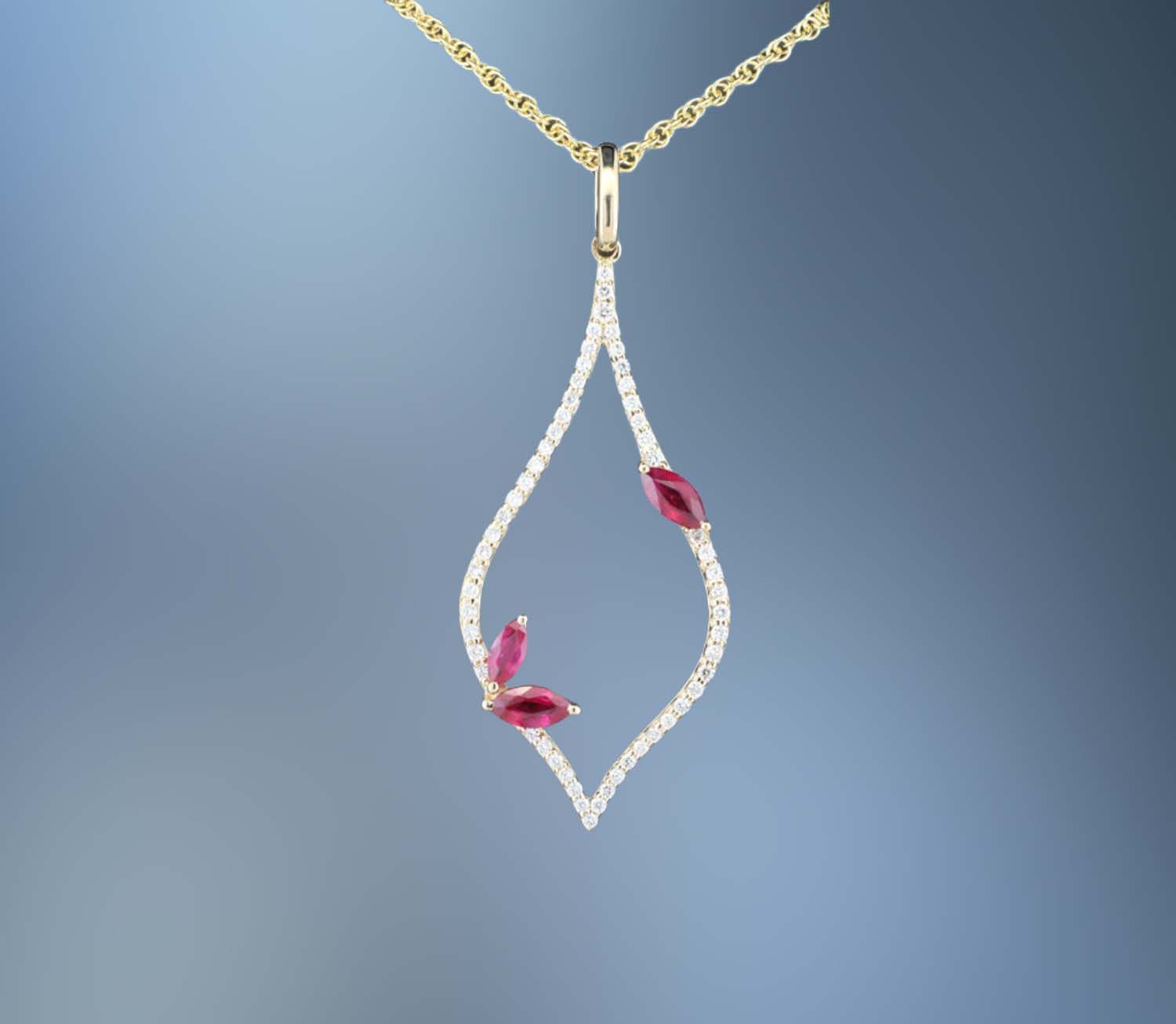 ONE 14KT YELLOW GOLD RUBY AND DIAMOND PENDANT CONTAINING .36 CTS OF MARQUISE SHAPE NATURAL RUBIES AND .56 CTS. OF NATURAL ROUND BRILLIANT CUT DIAMONDS ON AN 18 ONE 14KT YELLOW GOLD RUBY AND DIAMOND PENDANT CONTAINING .36 CTS OF MARQUISE SHAPE NATURAL RUBIES AND .56 CTS. OF NATURAL ROUND BRILLIANT CUT DIAMONDS ON AN 18" CHAIN WITH LOBSTER CLAW CLASP.