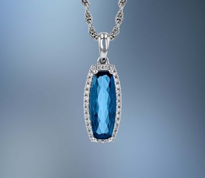 14KT WHITE GOLD BLUE TOPAZ & DIAMOND PENDANT FEATURING A 1.58 CT CUSHION CUT TOPAZ AND 30 ROUND BRILLIANT CUT DIAMONDS TOTALING 0.12 CTS 14KT WHITE GOLD BLUE TOPAZ & DIAMOND PENDANT FEATURING A 1.58 CT CUSHION CUT TOPAZ AND 30 ROUND BRILLIANT CUT DIAMONDS TOTALING 0.12 CTS
