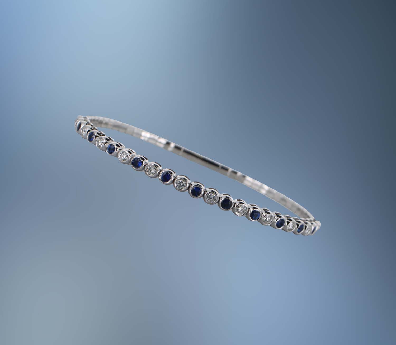 ONE 14KT WHITE GOLD LADIES DIAMOND AND SAPPHIRE FLEXIBLE BANGLE