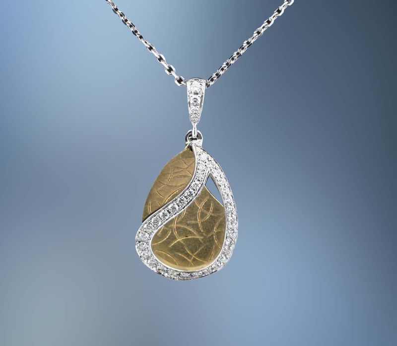 14KT TWO TONE DIAMOND PENDANT FEATURING 30 ROUND BRILLIANT CUT DIAMONDS TOTALING 0.20 CTS