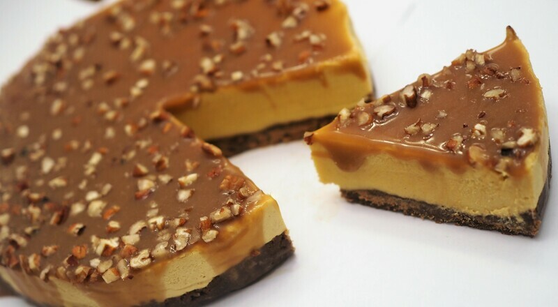 Vegan pumpkin cheesecake with caramel sauce and crushed pecans. GLUTEN FREE available.