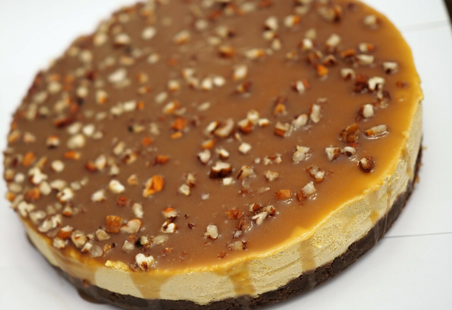 Vegan pumpkin cheesecake with caramel sauce and crushed pecans. GLUTEN FREE available.
