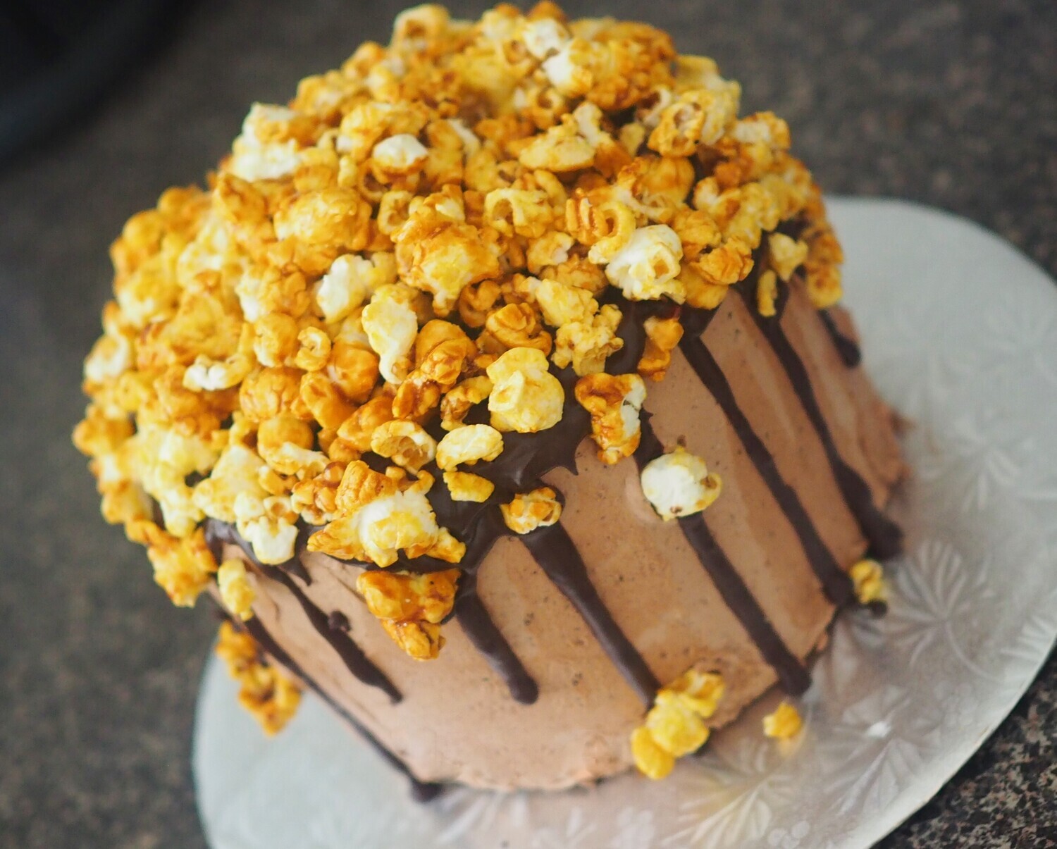 Vegan chocolate cake with chocolate swiss meringue buttercream and vegan caramel popcorn on the top. GLUTEN FREE available.