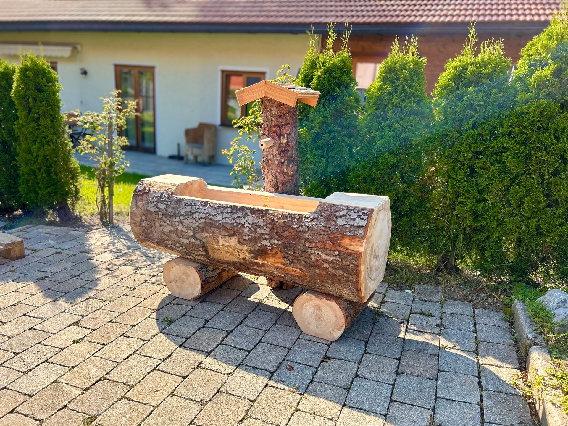 Wassertrog mit Rinde aus einem Baumstamm