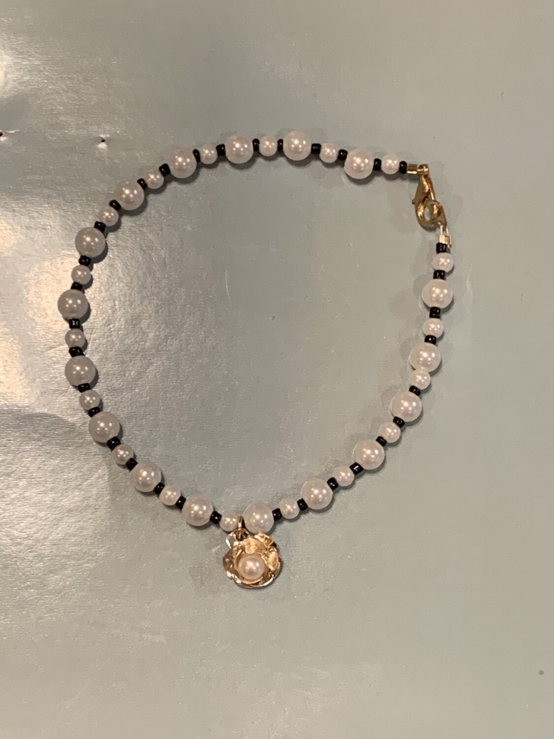 Black and white pearl anklet with gold flower charm