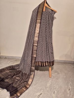 Elegant Black and White Patterned Saree with Gold Zari Border.
