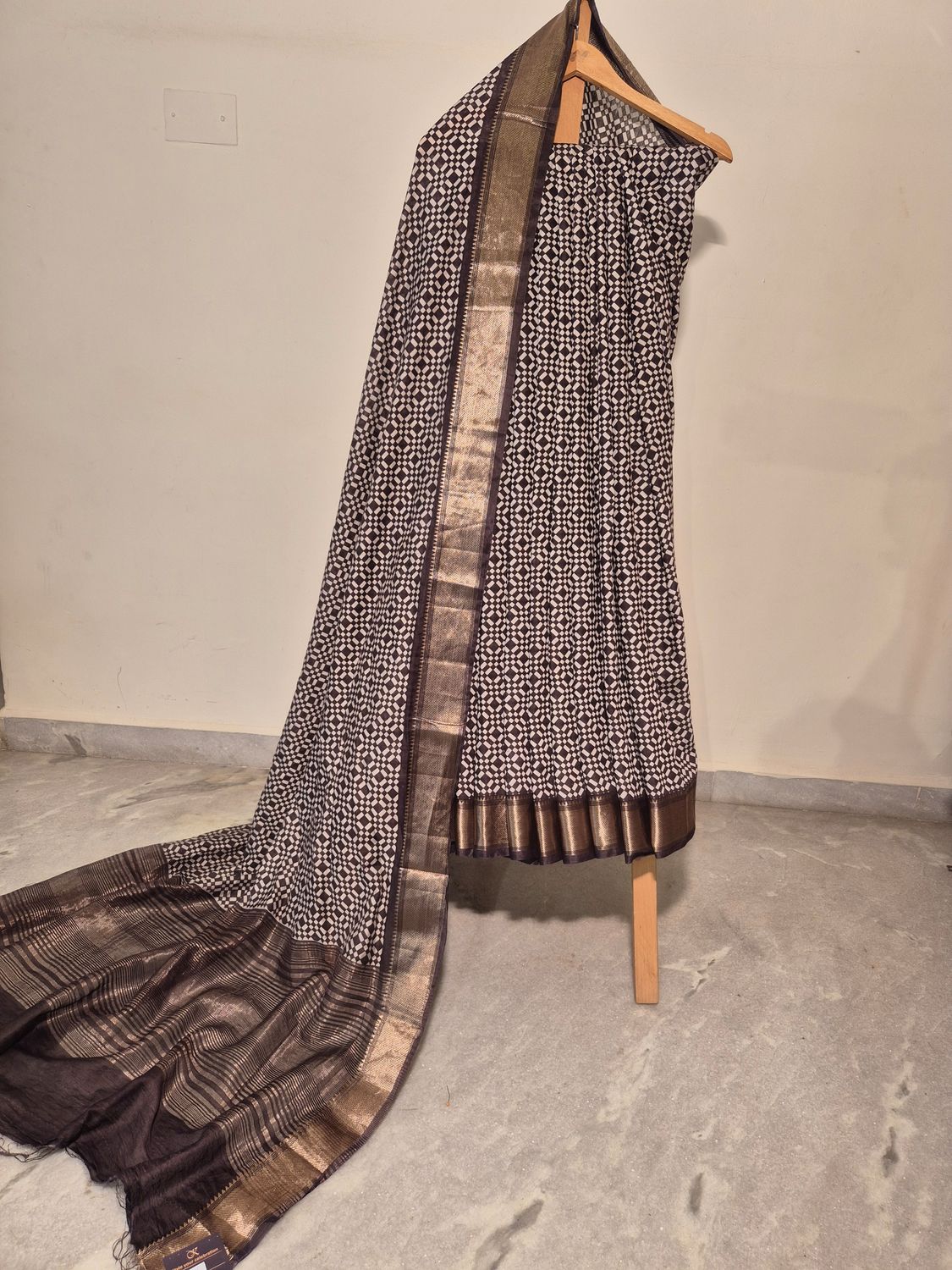 Elegant Black and White Patterned Saree with Gold Zari Border.