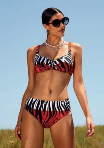 Nairobi Bikini by Nuria Ferrer. The fabric is a deep orange, black and white stylised animal print. Lifestyle photo.