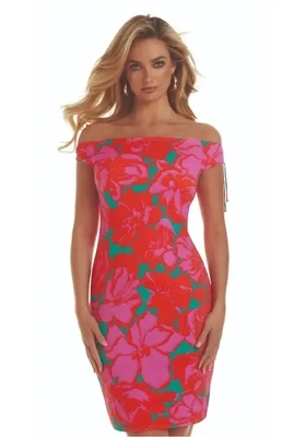 Roidal Floreale Alida Complice Dress. The fabric is a print of up-scaled blooms in bright pink and red with contrasting little flashes of emerald green. The hemline falls just above the knee. Golden tipped drawstrings at the shoulder can give a rise or fall effect, so the dress can be worn on or slightly off the shoulder