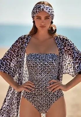 Roidal Noa Taria Bandeau Swimsuit. Black, Brown and White "dot and wave" fabric design. Lifestyle photo shows the swimsuit with matching beach cover up. 