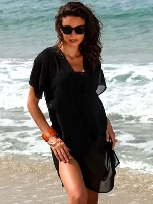 Lise Charmel Ajourage Couture Tunic Sundress. Lightweight tunic dress in black fabric with precisely cut lace effect band around the front and back necklines. Lifestyle photo.