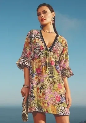 Palm Kaftan Dress by Nuria Ferrer. Abstract floral print fabric. The neckline is outlined by a black band with white embroidery, and below the bust there are drawstrings to add shape to the body.