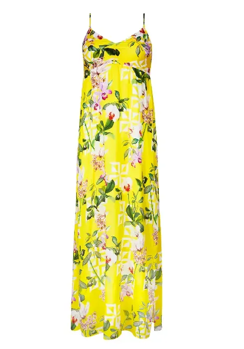 Lise Charmel Jardin Delice Maxi Dress. The fabric is a floral print on a yellow background. Lifestyle photo.