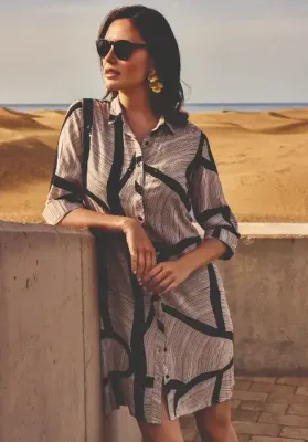 Lifestyle photo of the David Swimwear Geo Vibes Shirt Dress in a black and mocha design with button fastening at the front