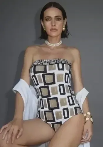 Geo Bandeau Swimsuit by Nuria Ferrer, a strapless swimsuit in a modern pale brown geometric print. Lifestyle photo.