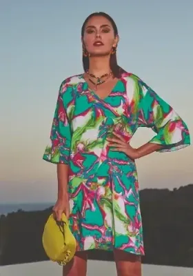 Frida Sundress Tunic by Nuria Ferrer, in a colourful emerald green and pink marbled print. Featuring a v-neckline and ¾ length sleeves the tunic hemline falls just above the knee. Lifestyle photo.