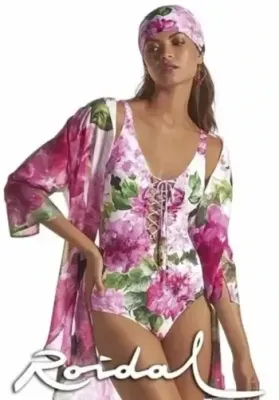 Roidal Larys Nina Lace Up Swimsuit. Pink floral design on a White background.  There are jewels at the end of the laces and the shoulder straps are adjustable.