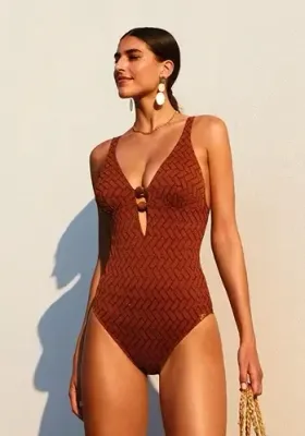 Siracusa Swimsuit by Nuria Ferrer Siracusa Swimsuit by Nuria Ferrer. The fabric is copper coloured with a metallic thread. Lifestyle photo.