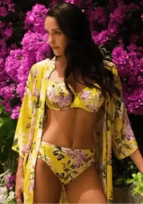 Lise Charmel Jardin Delice Bandeau Bikini in a floral print on  a yellow background. Lisestyle photo.