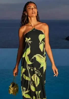 Fleurs de Nuit Maxi Dress by Lise Charmel. The fabric features a green stylised botanical print against a black background. Lifestyle photo.