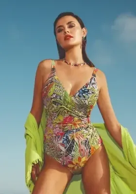 Palm Crossover Swimsuit by Nuria Ferrer. The Palm swimsuit features a figure flattering crossover front, with a decorative oval loop holding the gathered fabric in place. The fabric is an abstract floral print.