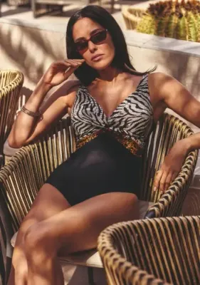 Lifestyle photo of David Swimwear Skin Alchemy Irma Comfy Swimsuit, in black with two complex prints – animal and floral .