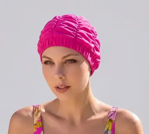 Close up of a model wearing a Fashy Pink Ruched shower cap. Suitable for wearing in the shower to protect your hair.