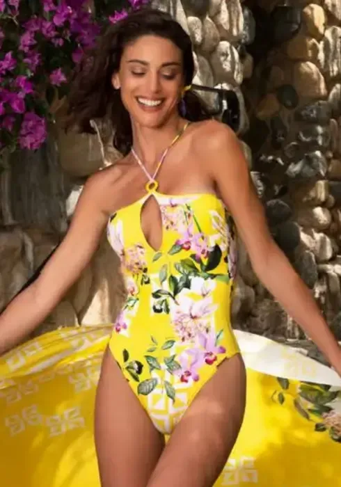 Lise Charmel Jardin Delice Halter Neck Swimsuit in a floral print on  a yellow background. Lisestyle photo.
