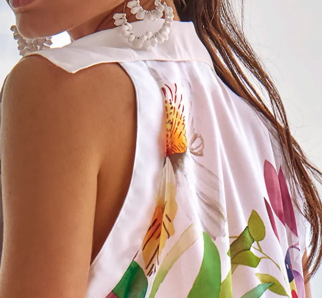 Lifestyle photo of Roidal Paraiso Faida Sleeveless Shirt Dress in a lightweight fabric with a pink floral pattern on white.