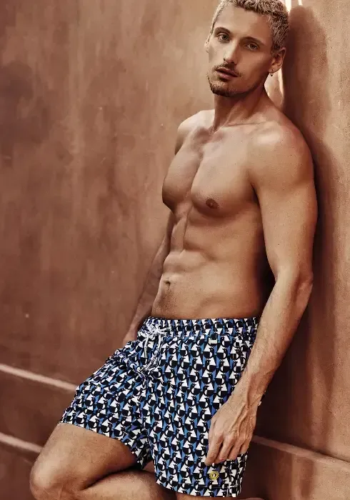 Caicco Gamer Swim shorts by David Italia. The design is a fun blue, black and white geometric print. With penguins!