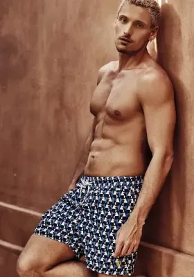 Caicco Gamer Swim shorts by David Italia. The design is a fun blue, black and white geometric print. With penguins!