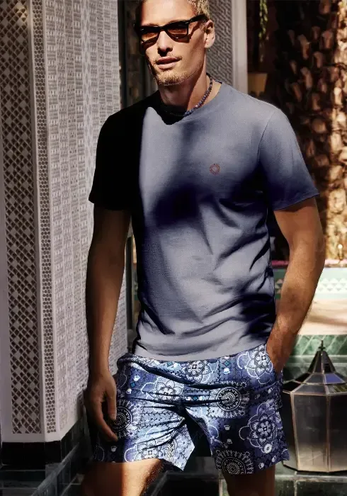 Lifestyle photo of Caicco Bandhani swim shorts by David Italia. Indian style print on a blue denim style background