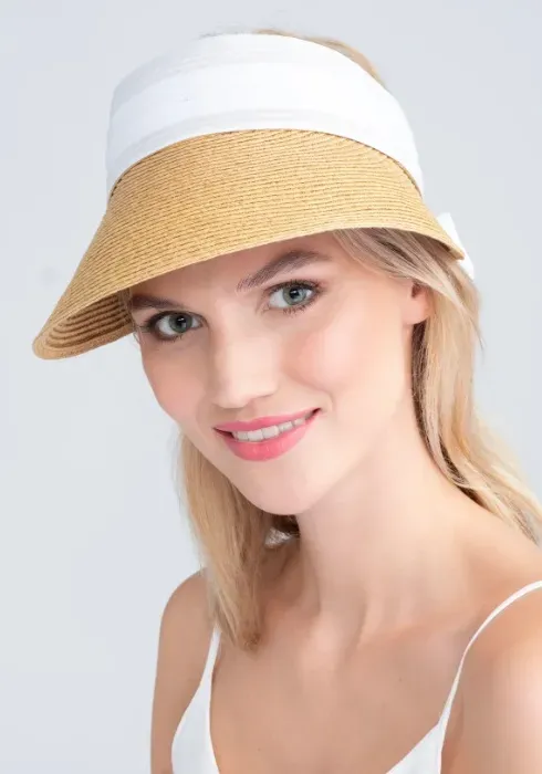 Lifestyle photo of Misha Visor in natural woven tone with white material band that can be tied into a bow to fasten.