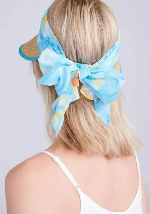 Lifestyle photo of Misha Visor in Natural & Turquoise. A woven visor with turquoise floral material.