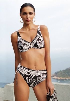 Model wearing a black and white tropical print Nuria Ferrer Bahia bikini set with an underwire top and tie-side bottoms.