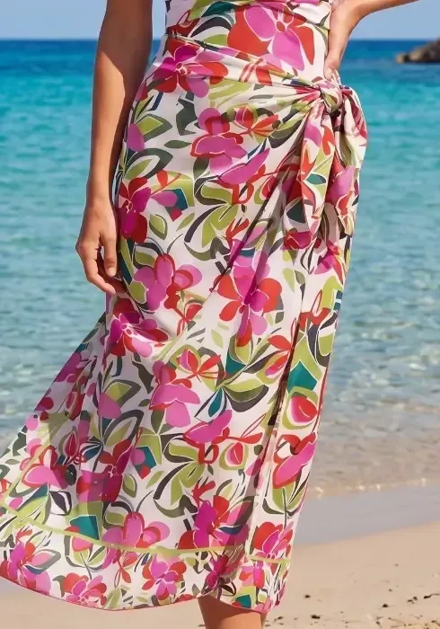 Close up of a model wearing a Hana Pareo by Nuria Ferrer by the sea. The fabric is an attractive multicoloured floral design