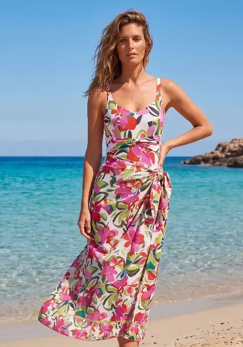 Close up of a model wearing a Hana Pareo by Nuria Ferrer by the sea. The fabric is an attractive multicoloured floral design