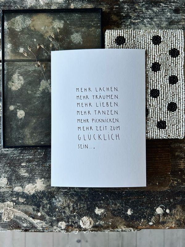 “ Mehr glücklich sein…” Postkarte von Slowlay