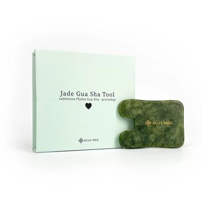 Jade Gua Sha -lasta ja sen tuotepakkaus valkoisella taustalla – kasvohierontaan ja verenkierron vilkastuttamiseen

