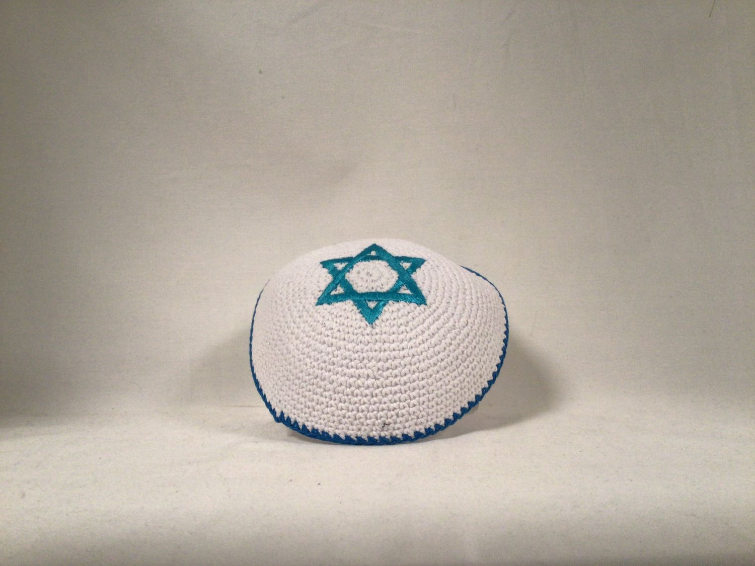 White Knitted Kippah with tourquise   Blue Star of David and an Edging row.