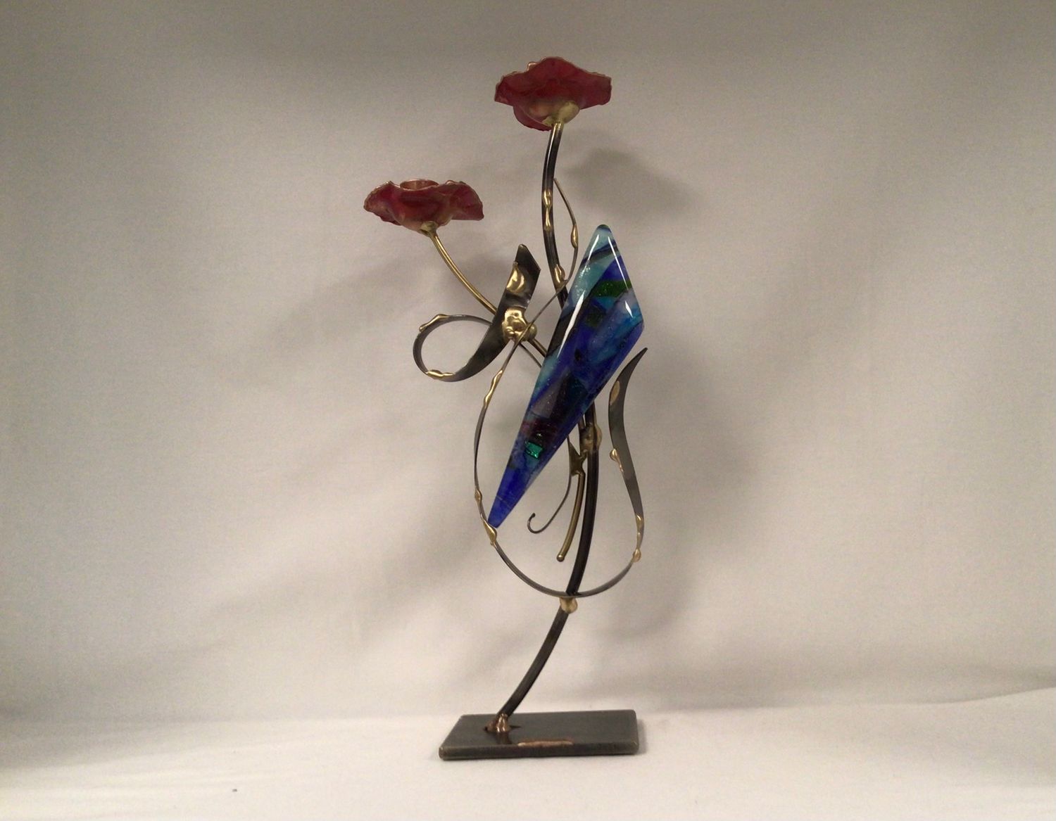 Flowering candlesticks with metal form and colorful glass accent.