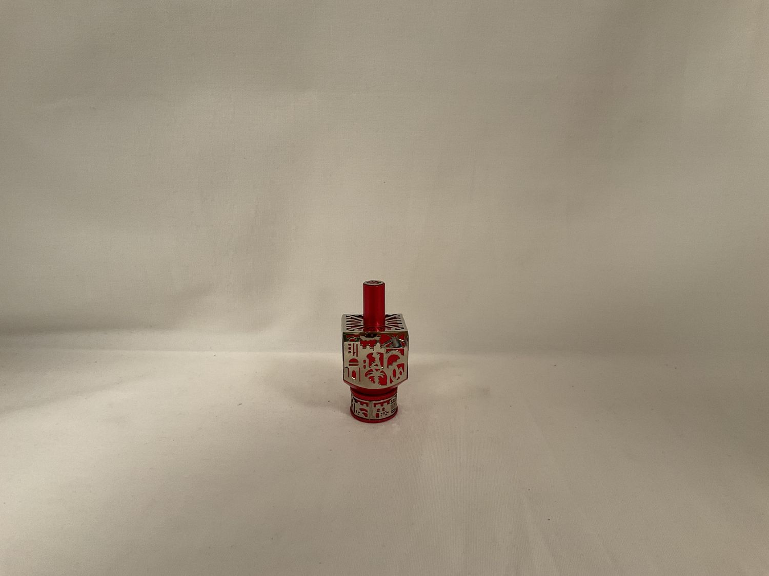 Anodized Red Dreidel with Jerusalem Cutout on Stand Anodized Red Dreidel with Jerusalem Cutout on Stand