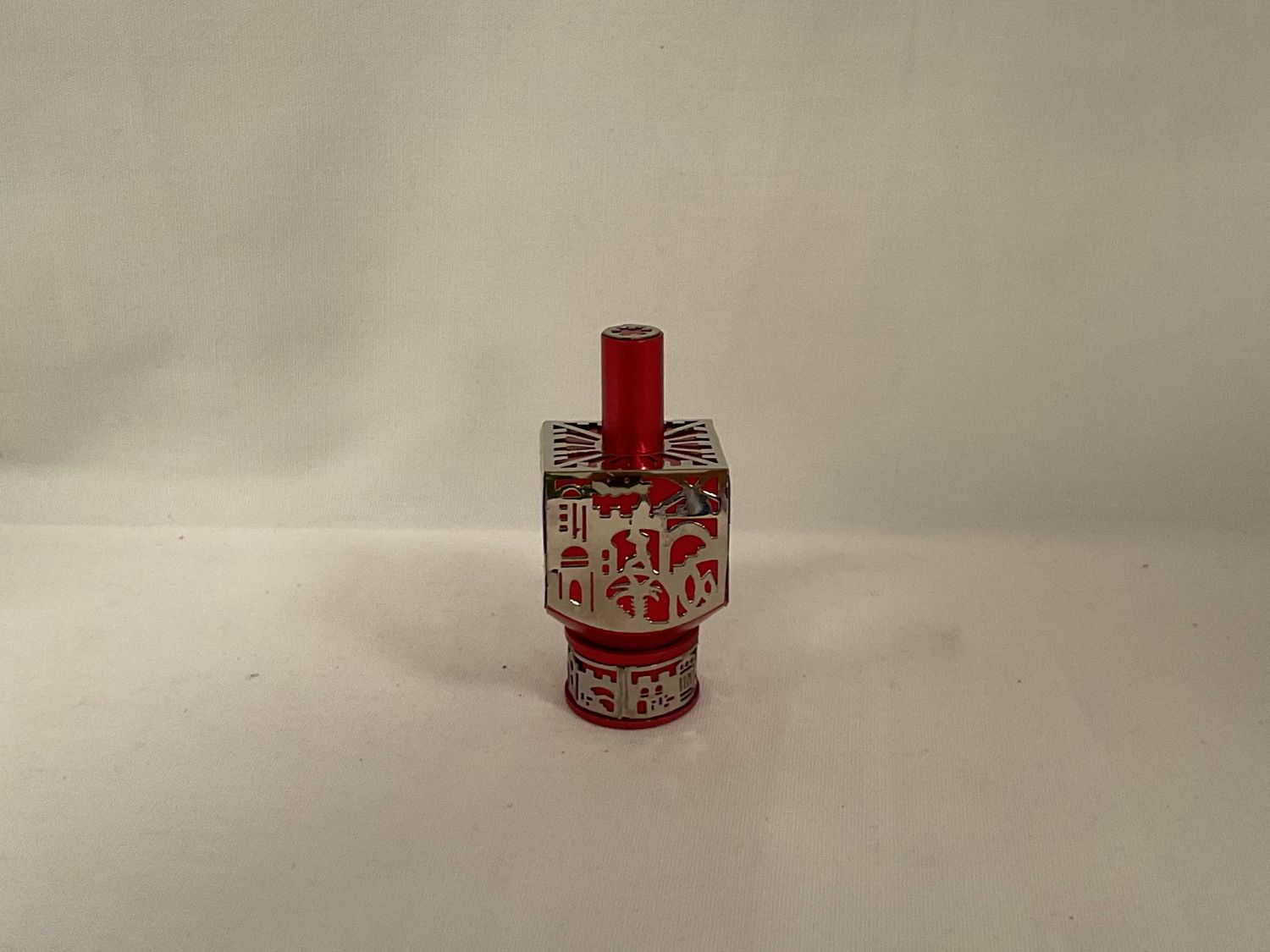 Anodized Red Dreidel with Jerusalem Cutout on Stand Anodized Red Dreidel with Jerusalem Cutout on Stand