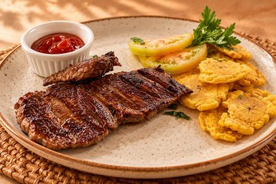 Churrasco con tostones y limón