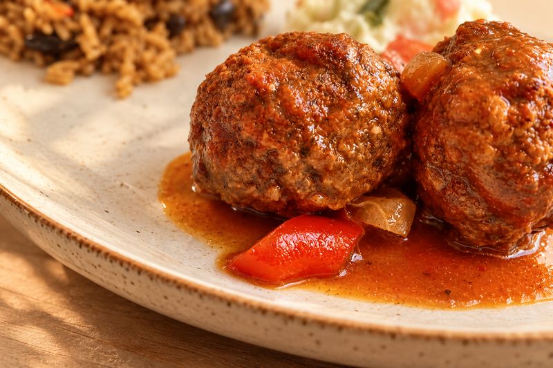 Albóndigas guisadas en salsa de tomate servidas en plato de cerámica