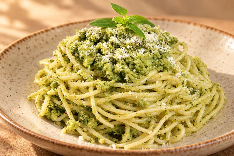 Pasta al pesto servida en plato de cerámica