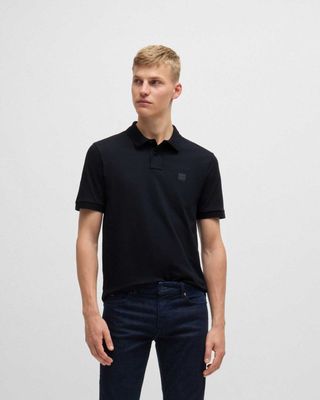 Man draagt donkerblauwe Hugo Boss polo met jeans, vooraanzicht