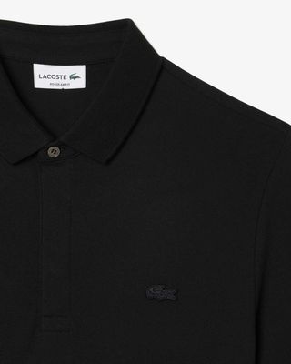 Detail van de Lacoste Paris polo PH5522 in zwart met ton-sur-ton logo en verborgen sluiting