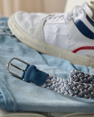 Beverly Hills lichtblauwe suède riem op lichtblauwe jeans met witte sneakers