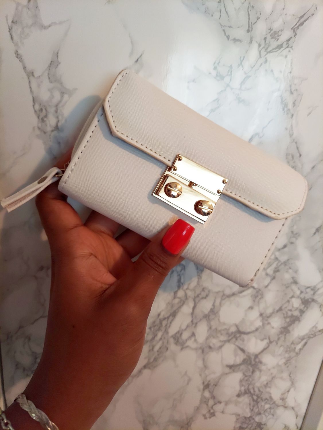 White wallet with gold hardware